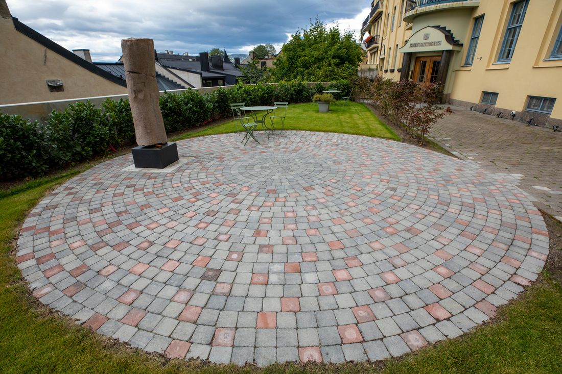 Uteplass av betongstein og beplantning av hekk